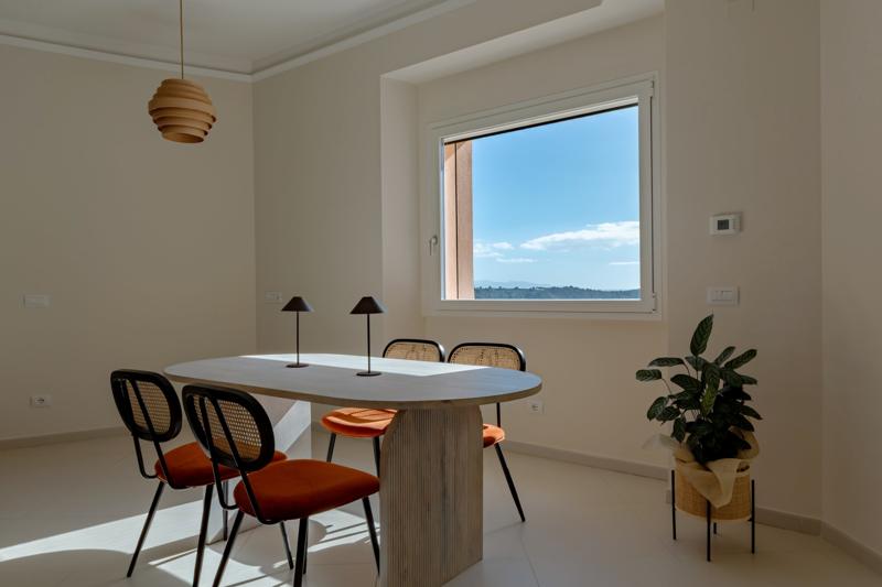 Dining table beside a window overlooking green hills