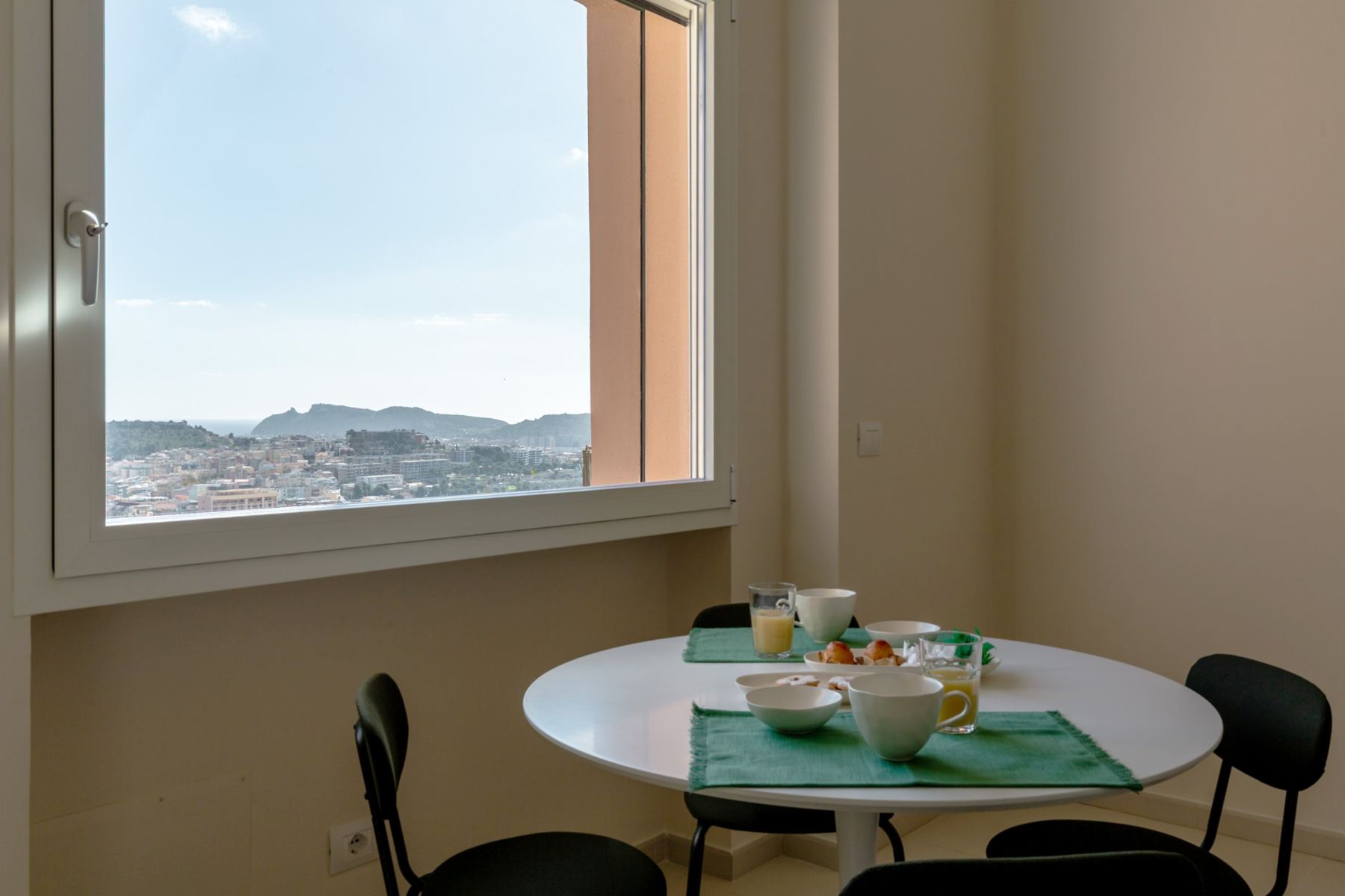 Breakfast table by a window with a view of the Sella del Diavolo headland
